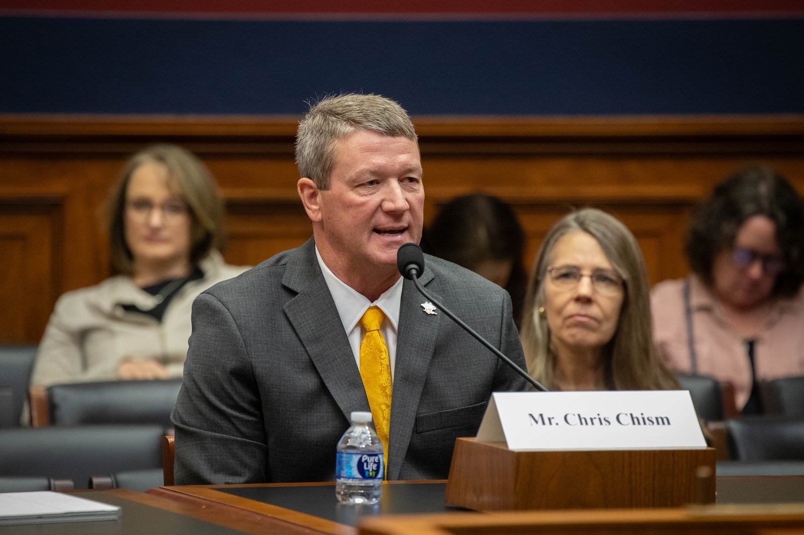 Chris Chism testifying at the U.S. House Committee on Education and the Workforce, name placard reading 'Mr. Chris Chism' at the microphone